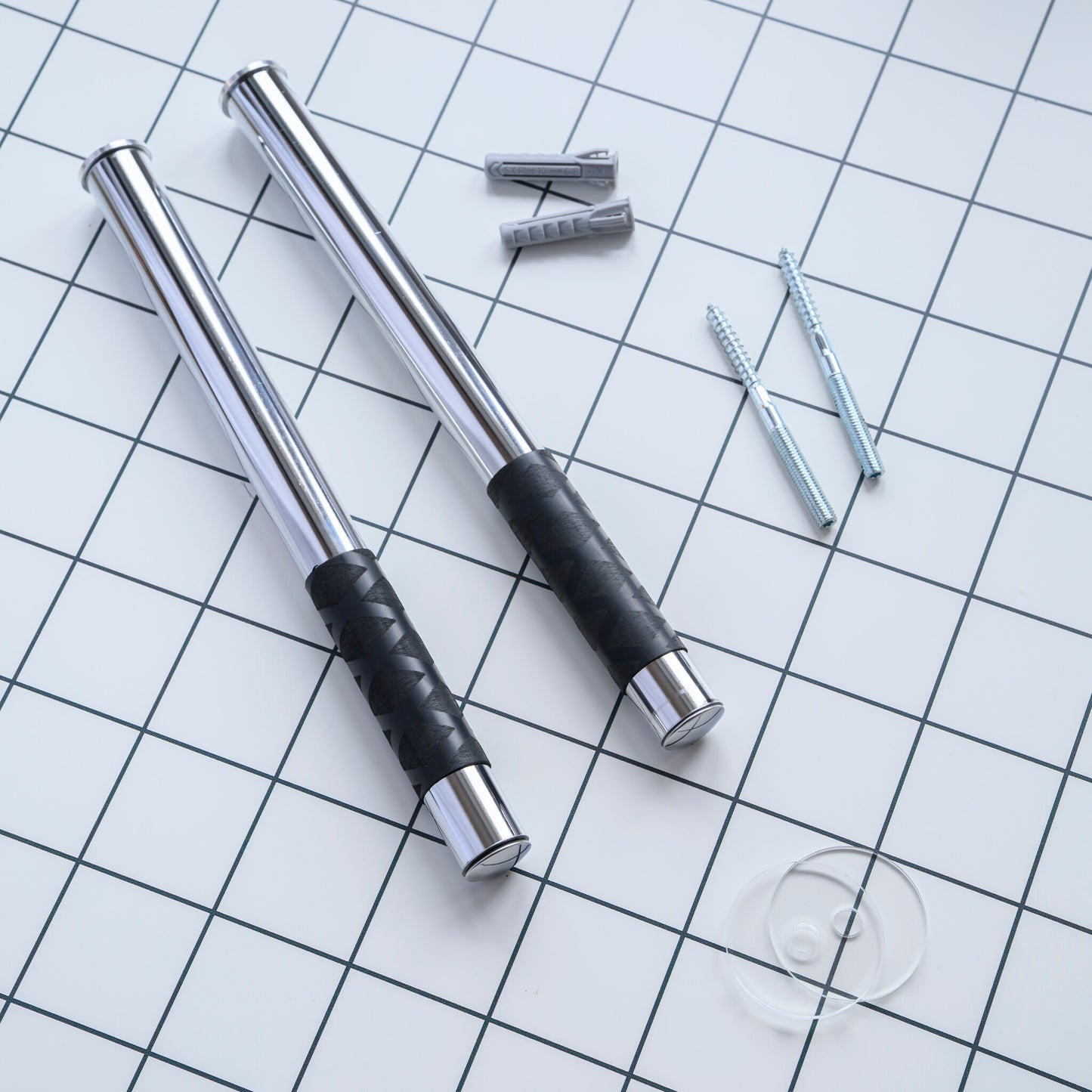 Metal bike wall mount with black rubber grip surface on a grid background

